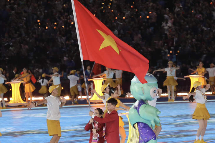 Nguyễn Huy Hoàng và Nguyễn Thị Hường cầm cờ cho đoàn Việt Nam - Ảnh: ĐỨC KHUÊ