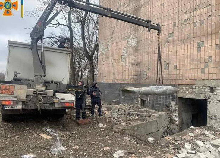 Đặc công của Cơ quan Khẩn cấp nhà nước Ukraine đang tháo dỡ quả bom Nga không nổ FAB-500 ở Kharkiv - Ảnh: REUTERS
