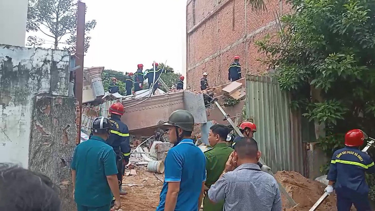 Lực lượng chức năng đang đào bới trong đống đổ nát của căn nhà sập, tìm kiếm người mất tích - Ảnh: MINH HÒA