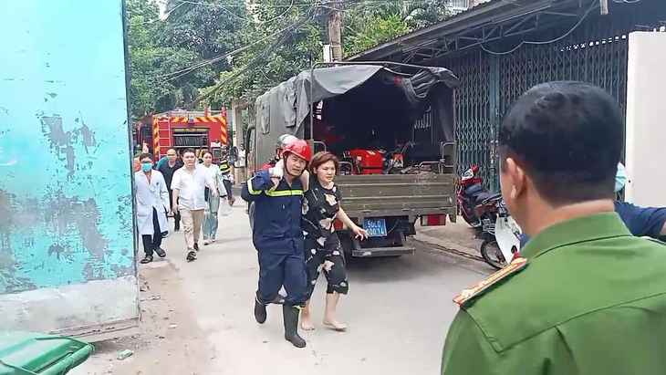 Một người phụ nữ khác cũng được lực lượng chức năng đưa ra ngoài xe cứu thương - Ảnh: MINH HÒA