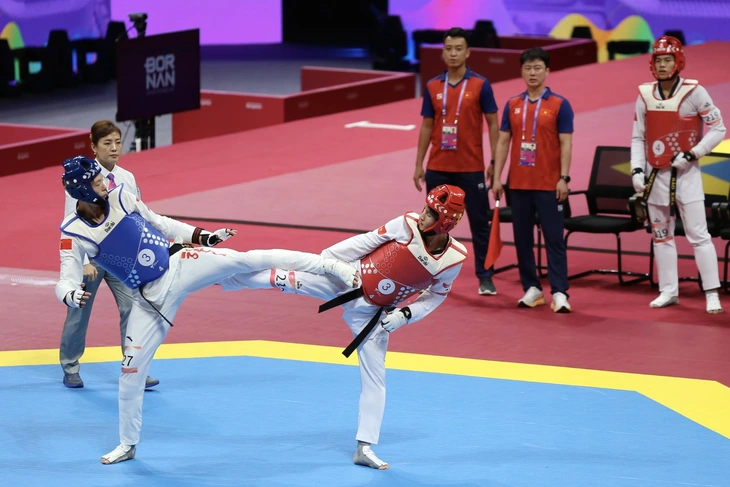 Asiad 19 ngày 25-9: Việt Nam giành 3 HCĐ, 1 HCB - Ảnh 2. Kim Tuyền (giáp đỏ) dừng chân ở tứ kết 49kg nữ môn taekwondo - Ảnh: ĐỨC KHUÊ