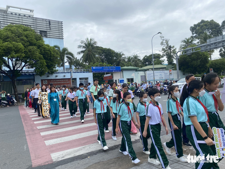 Thầy, cô giáo dẫn các em học sinh Trường THCS Hà Huy Tập sang đường đúng cách, an toàn - Ảnh: THU DUNG