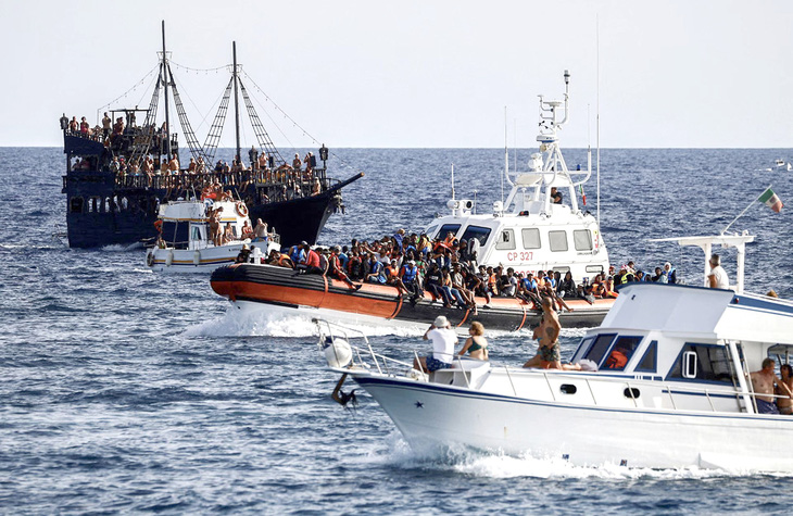 Tàu hải cảnh Ý chở những người di cư được giải cứu trên biển và các tàu du lịch di chuyển ở đảo Lampedusa (Ý) vào hôm 18-9 - Ảnh: REUTERS