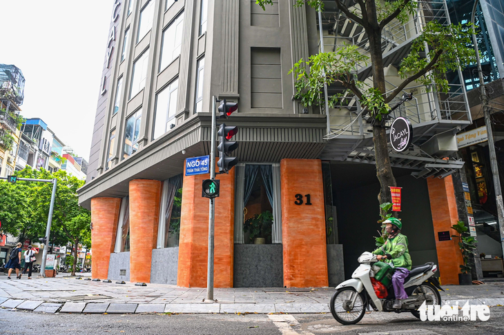 Một khách sạn trên đường Trần Thái Tông, quận Cầu Giấy, dùng loại thang có thể gấp gọn lên phía trên khi không sử dụng - Ảnh: HỒNG QUANG