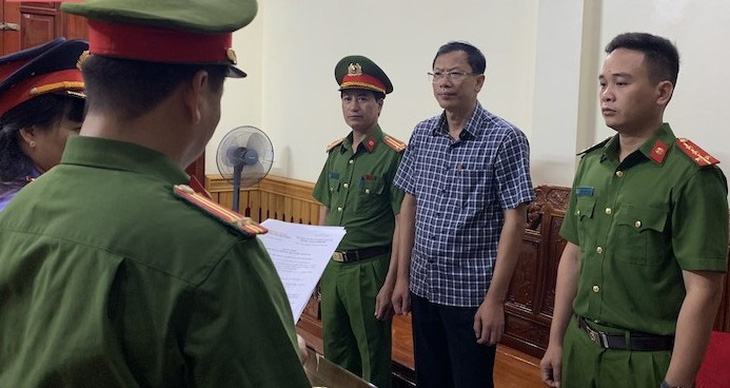 Cơ quan cảnh sát điều tra thi hành lệnh bắt tạm giam bị can Nguyễn Văn Hùng (mặc áo sọc) - hiệu trưởng Trường cao đẳng Công nghiệp Thanh Hóa - Ảnh: Công an cung cấp