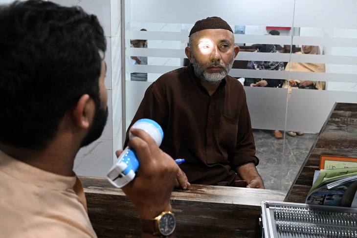 Bác sĩ khám cho bệnh nhân đau mắt đỏ ở Pakistan, ngày 27-9 - Ảnh: AFP