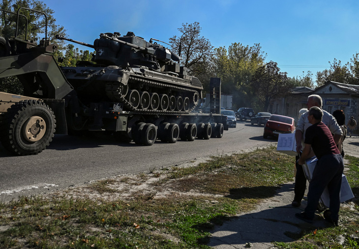 Người dân địa phương nhìn pháo phòng không tự hành Gepard đi ngang qua vùng Kharkov, Ukraine, ngày 25-9 - Ảnh: REUTERS