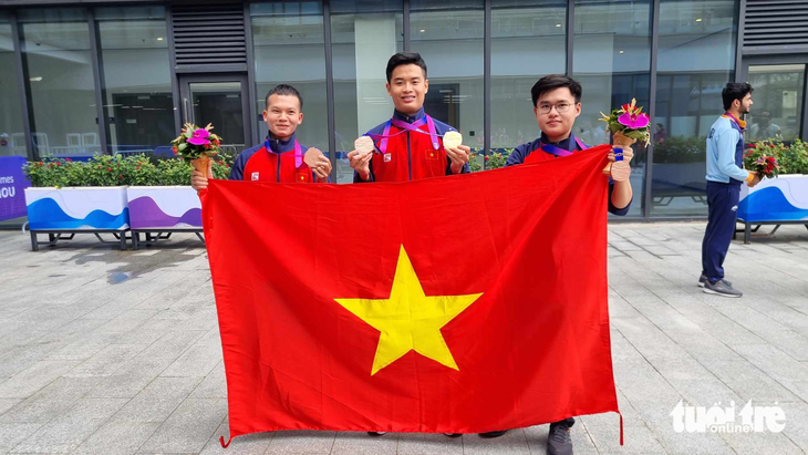 Phạm Quang Huy và các đồng đội cầm cờ Việt nam ăn mừng huy chương tại Asiad 19 - Ảnh: HUY ĐĂNG