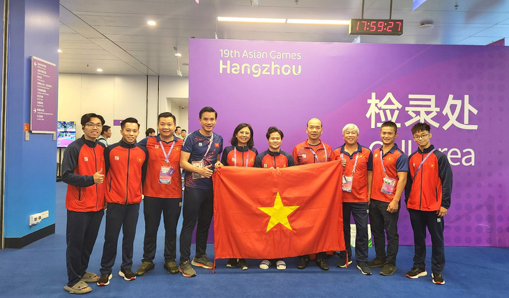 Khánh Phong hạnh phúc bên các thành viên đội thể dục dụng cụ, lãnh đạo đoàn thể thao Việt Nam tham dự Asiad 19 - Ảnh: Cục TDTT