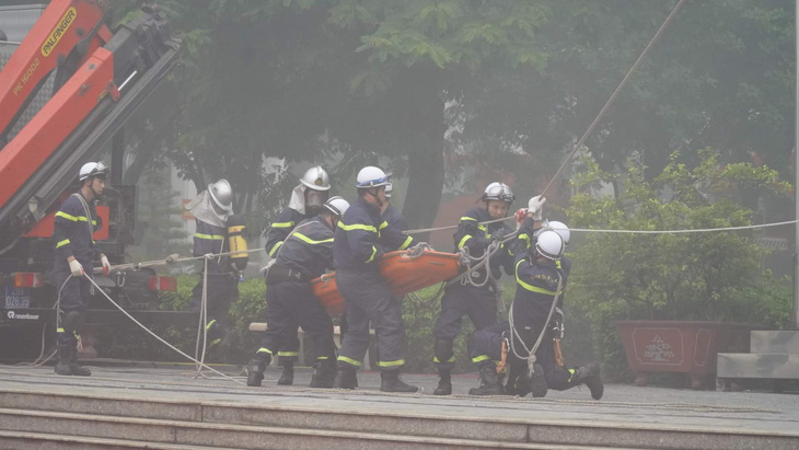 Cảnh sát phòng cháy chữa cháy và cứu nạn cứu hộ diễn tập phương án đưa người mắc kẹt trong đám cháy ra ngoài - Ảnh: ĐẠI HIỆP
