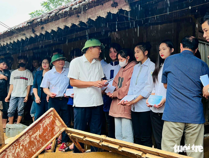 Ông Thái Văn Thành - giám đốc Sở Giáo dục và Đào tạo Nghệ An - trao tiền hỗ trợ các em học sinh Trường THPT Quỳ Châu ở trọ bị thiệt hại do mưa lũ - Ảnh: ĐẶNG HẢI