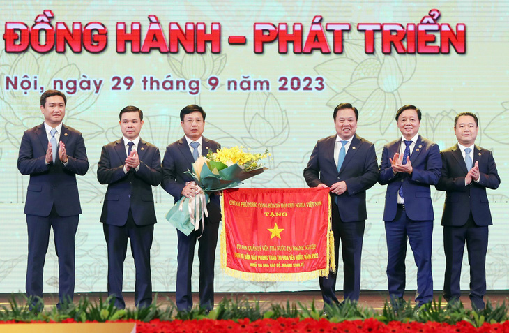 Phó thủ tướng Trần Hồng Hà tặng cờ thi đua của Chính phủ cho lãnh đạo Ủy ban Quản lý vốn nhà nước tại doanh nghiệp - Ảnh: M.K.