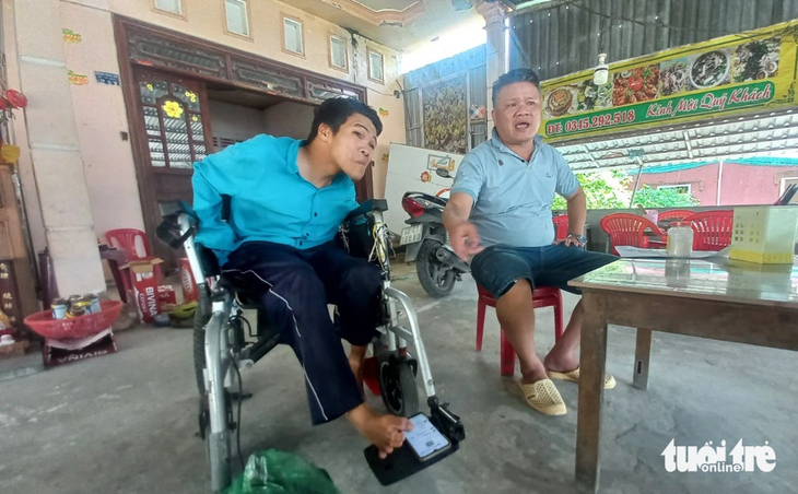 Anh Phạm Thanh Tùng (trái) sử dụng điện thoại mở tài liệu cho chúng tôi, còn anh Phạm Văn Sơn bức xúc kể - Ảnh: BỬU ĐẤU