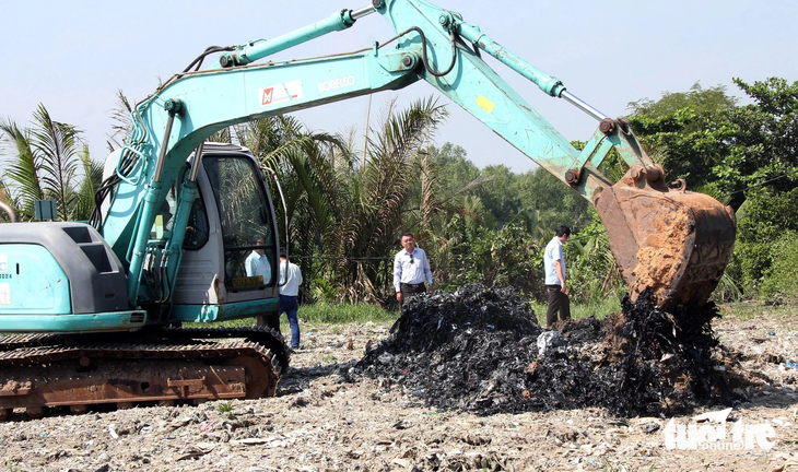 Lực lượng chức năng khai quật khu vực san lấp tại ấp 2, xã Phong Phú, huyện Bình Chánh ngày 22-11-2018  - Ảnh: QUANG KHẢI