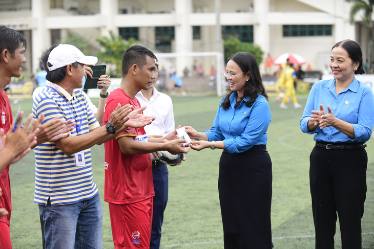 Chủ tịch Liên đoàn Lao động TP Cần Thơ - bà Lê Thị Sương Mai (giữa) trao tiền thưởng nóng cho cầu thủ Công đoàn Cần Thơ giữa hiệp đấu - Ảnh: QUANG ĐỊNH
