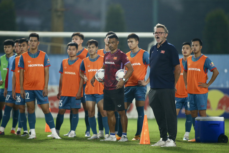 HLV Philippe Troussier (áo xanh đen) đang nâng cao các yêu cầu kỹ chiến thuật đối với cầu thủ U23 và tuyển Việt Nam - Ảnh: HOÀNG TÙNG
