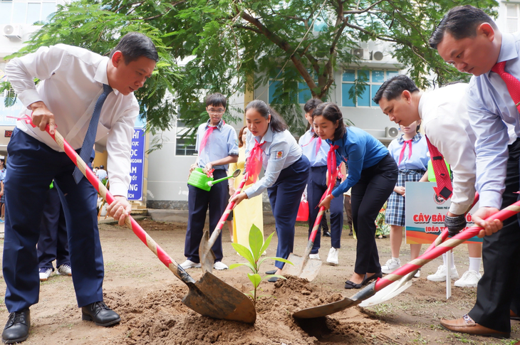 Lãnh đạo cùng thầy và trò Trường THCS Phạm Hữu Lầu (quận 7) trồng cây bàng vuông do chiến sĩ Trường Sa gửi tặng - Ảnh: K.ANH