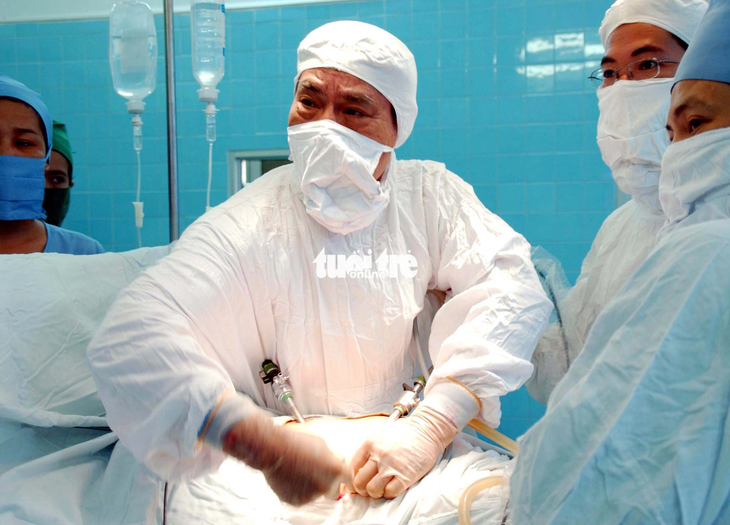 Giáo sư Văn Tần cùng các y bác sĩ thực hiện ca nội soi túi mật cho bệnh nhân Trần Thị Út, tại Bệnh viện Bình Dân, ngày 17-5-2006 - Ảnh: NGUYỄN CÔNG THÀNH