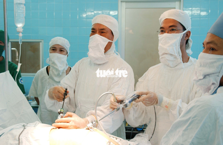 Giáo sư Văn Tần trong ca phẫu thuật tách đôi cặp song sinh dính liền Việt - Đức tại Bệnh viện Từ Dũ ngày 4-10-1988 - Ảnh: NGUYỄN CÔNG THÀNH