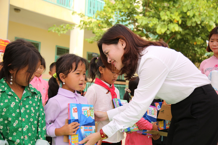 Chị Đỗ Thị Kim Hoa, giám đốc Trung tâm Tình nguyện quốc gia, tặng quà cho các em học sinh nhân ngày lễ khai giảng năm học mới - Ảnh: Hội LHTN Việt Nam