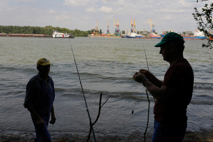 Hai người đàn ông chuẩn bị câu cá trên sông Danube ở Plauru, Romania, đối diện cảng Izmail của Ukraine, ngày 5-9 - Ảnh: REUTERS