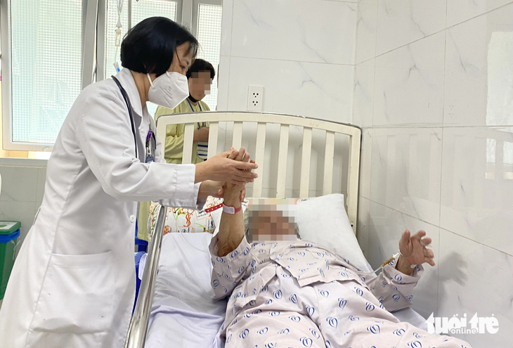 Bác sĩ Bệnh viện Thống Nhất (TP.HCM) thăm khám, đánh giá khả năng phục hồi sau đột quỵ cho một bệnh nhân - Ảnh: XUÂN MAI 