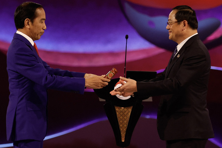 Tổng thống Indonesia Joko Widodo trao búa Chủ tịch luân phiên ASEAN cho Thủ tướng Lào Sonexay Siphandone - Ảnh: AFP