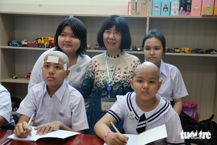 Cô Đinh Thị Kim Phấn cùng bệnh nhi ung thư trong ngày khai giảng - Ảnh: NGUYÊN KHANG