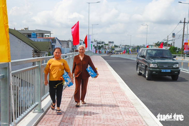 Bà con huyện Nhà Bè (TP.HCM) phấn khởi đi trên cây cầu Long Kiểng mới - Ảnh: CHÂU TUẤN
