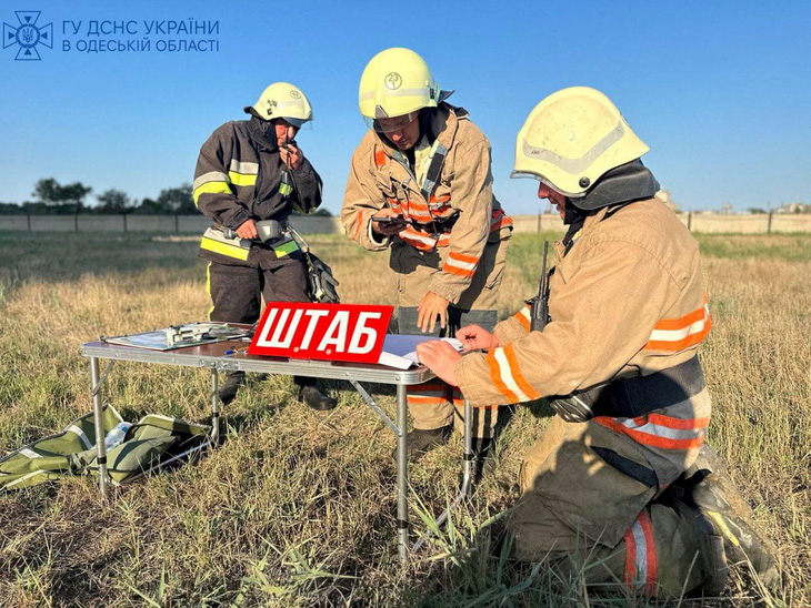 Lính cứu hỏa Ukraine đang làm việc tại Odessa sau các cuộc tấn công bằng drone ngày 6-9 - Ảnh: REUTERS