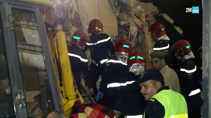 Lực lượng cứu hộ tìm kiếm những người còn mắc kẹt trong đống đổ nát - Ảnh: REUTERS