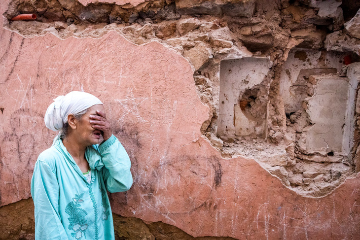 Một phụ nữ Morocco bật khóc trước tòa nhà đổ nát sau động đất - Ảnh: AFP