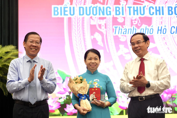 Chủ tịch UBND TP.HCM Phan Văn Mãi (trái) và Bí thư Thành ủy Nguyễn Văn Nên (phải) biểu dương bí thư chi bộ khu phố tiêu biểu - Ảnh: HỮU HẠNH