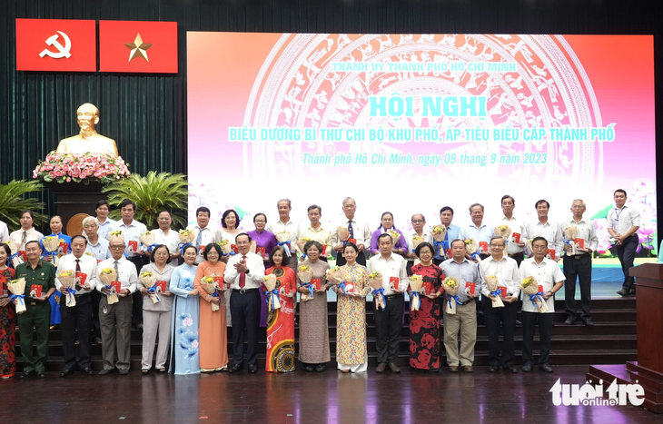 Bí thư Thành ủy TP.HCM Nguyễn Văn Nên tận tay trao các đóa hoa tươi thắm cùng biểu trưng cho 235 cá nhân được biểu dương - Ảnh: HỮU HẠNH 