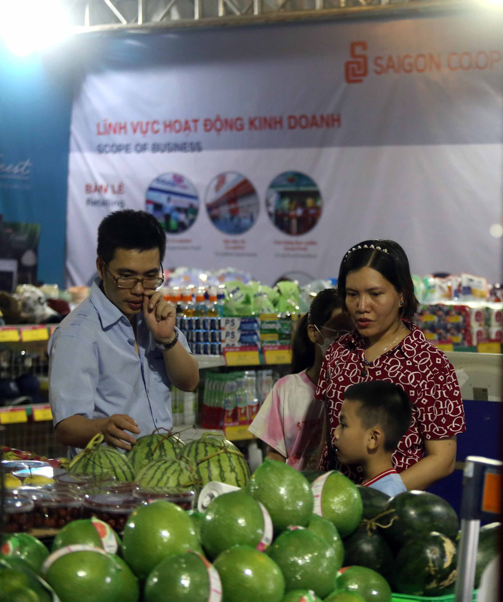 Một gia đình ba mẹ con đến tham khảo, mua sắm tại gian hàng của Saigon Co.op