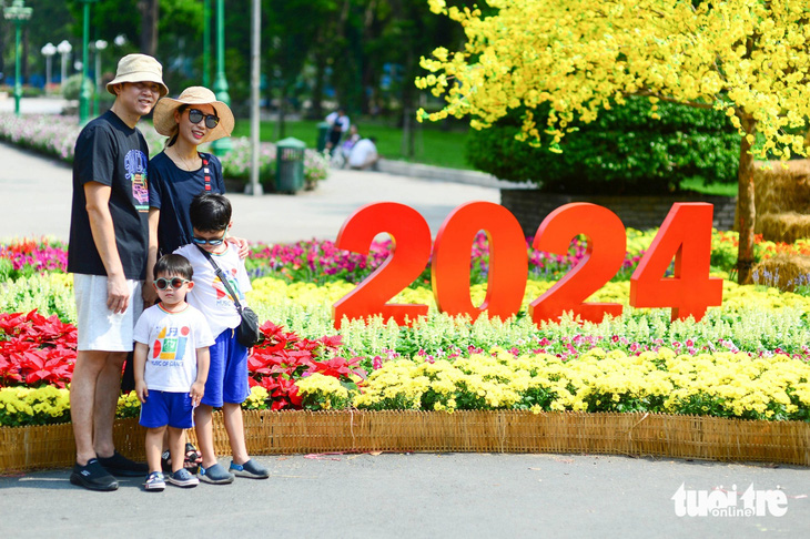 Du khách Hàn Quốc chụp ảnh kỷ niệm 2024 tại công viên Lê Văn Tám, quận 1, TP.HCM dịp Tết dương lịch - Ảnh: QUANG ĐỊNH