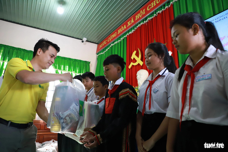 Anh Trương Duy Phương - giám đốc bán hàng khu vực Bách hóa xanh Đắk Lắk - trao quà cho các cháu học sinh có hoàn cảnh khó khăn - Ảnh: TRUNG TÂN