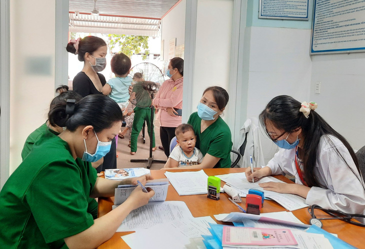 Phụ huynh đưa trẻ đi tiêm vắc xin trong chương trình tiêm chủng mở rộng tại trạm y tế ở TP.HCM - Ảnh: THU HIẾN