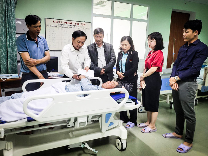 Chính quyền thị xã Điện Bàn đến bệnh viện thăm hỏi và trao hỗ trợ bước đầu cho ông Nguyễn Thanh Hùng bị mảnh vỡ máy bay văng trúng đầu - Ảnh: H.D. 