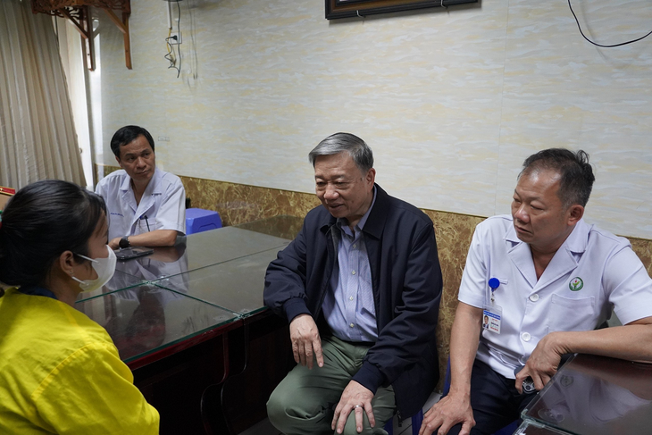Bộ trưởng Tô Lâm (thứ 2 từ phải qua) và giám đốc Bệnh viện Việt Đức (bìa phải) động viên, chia sẻ với thân nhân cảnh sát giao thông bị thương khi làm nhiệm vụ - Ảnh: Công an cung cấp