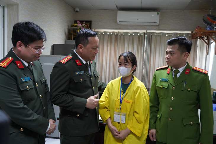 Đại tá Phạm Thanh Hùng, phó giám đốc Công an TP Hà Nội, động viên vợ đại úy Nguyễn Văn Thưởng - Ảnh: Công an cung cấp