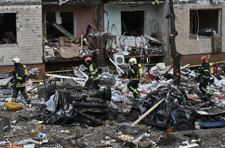 Lực lượng cứu hỏa Ukraine tại đống đổ nát một tòa chung cư chịu thiệt hại nặng nề sau cuộc tấn công của Nga vào thủ đô Kiev ngày 2-1 - Ảnh: AFP