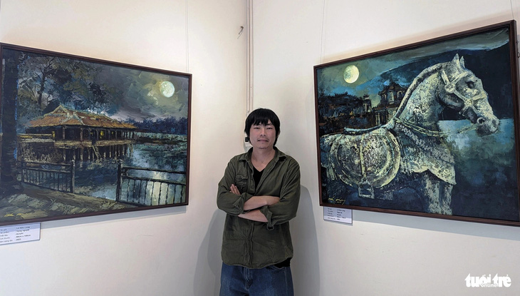 Họa sĩ Lê Hữu Long bên tác phẩm tại triển lãm tranh &quot;Vọng Huế&quot; - Ảnh: NHẬT LINH