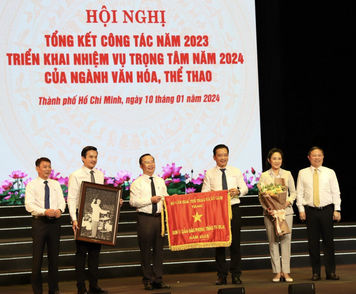 Ông Dương Anh Đức (bìa phải) trao cờ thi đua của Bộ Văn hóa, Thể thao và Du lịch cho Sở Văn hóa và Thể thao TP.HCM - Ảnh: HOÀI PHƯƠNG