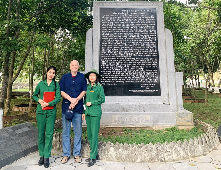 Ông Jay Gray chụp ảnh lưu niệm cùng nhân viên Ban quản lý Khu di tích Ngã ba Đồng Lộc - Ảnh: H.A.