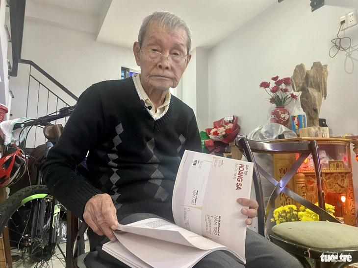 Cụ Phạm Sô (90 tuổi, trú tại phường Bình Hiên, quận Hải Châu) vui mừng khi nhận được tập Tư liệu Hoàng Sa có những trang viết về mình trong đó - Ảnh: TRƯỜNG TRUNG