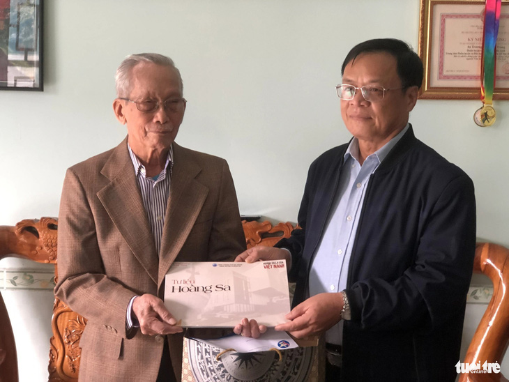 Lãnh đạo UBND huyện Hoàng Sa tặng tập Tư liệu Hoàng Sa cho cụ Trương Văn Quảng, một nhân chứng từng sống tại Hoàng Sa - Ảnh: MINH NGUYỆT