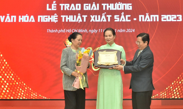 Nhà văn Bích Ngân nhận giải thưởng thay nhà văn Nguyễn Thị Minh Ngọc - Ảnh: TẤN THẠNH