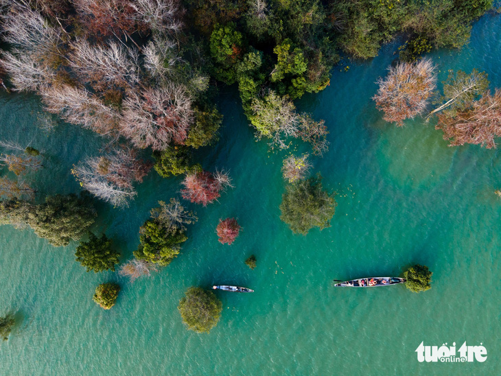 Du khách đi thuyền ngắm phong hương đổi màu ở lòng hồ thủy lợi thủy điện Rào Quán - Ảnh: HOÀNG TÁO