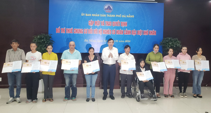 Ông Lê Trung Chinh, chủ tịch UBND TP Đà Nẵng, trao quyết định bố trí thuê chung cư cho 44 hộ nghèo có hoàn cảnh đặc biệt khó khăn trên địa bàn - Ảnh: NHỊ TRÌNH